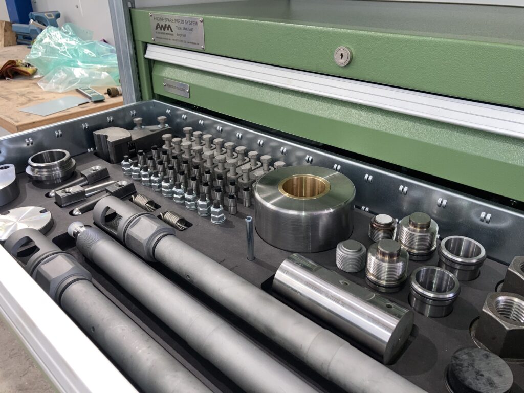 Werkzeugschublade mit sortierten Spezialteilen für Schiffsmotoren.