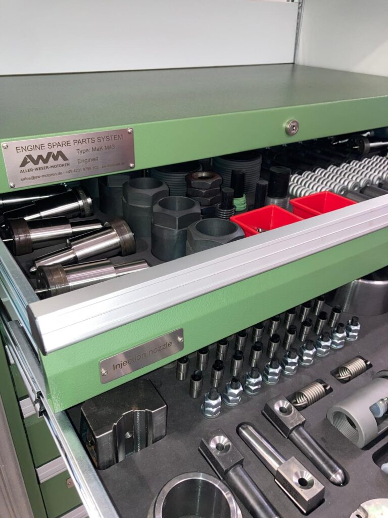 Werkzeugschublade mit Einspritzdüsen und Ersatzteilen.