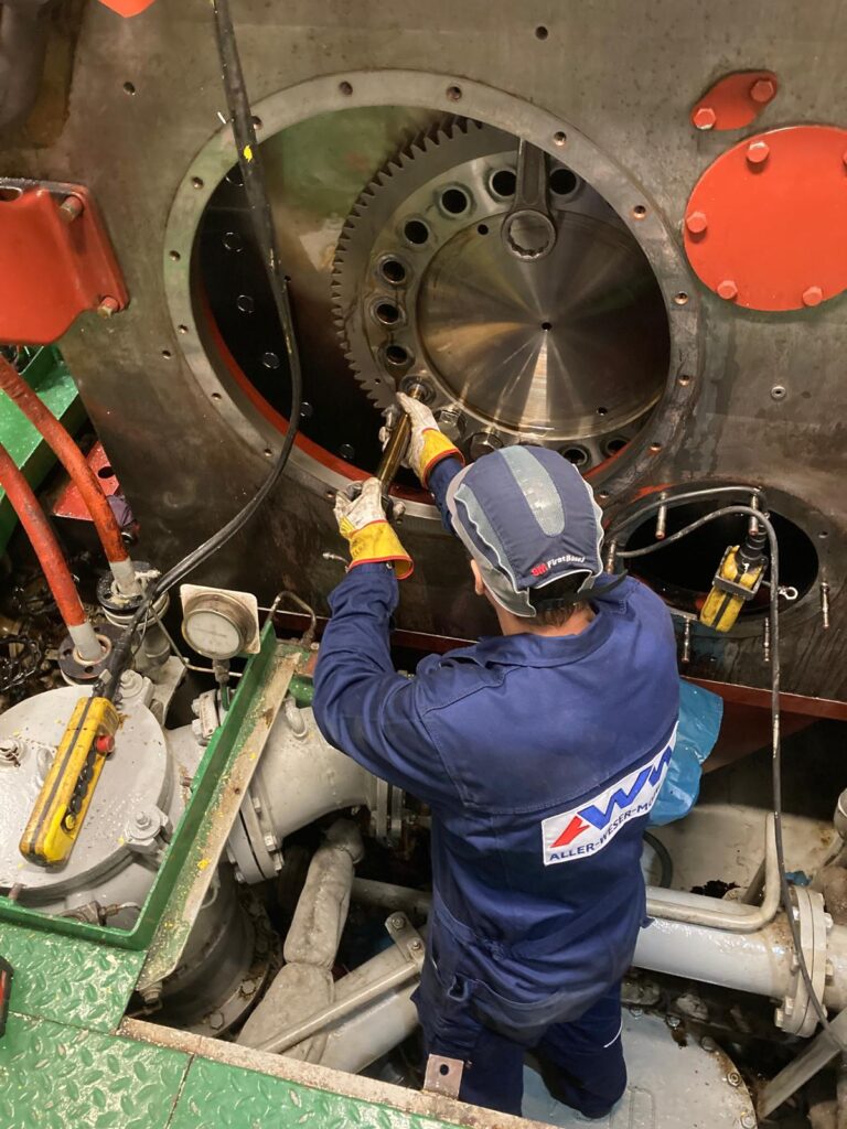 Mechaniker arbeitet am offenen Schwungradgehäuse.